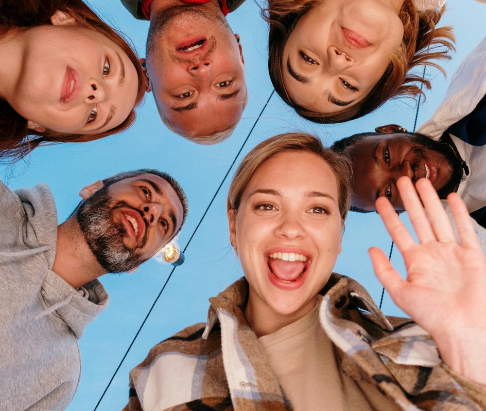groep mensen die overgebogen naar een camera kijken